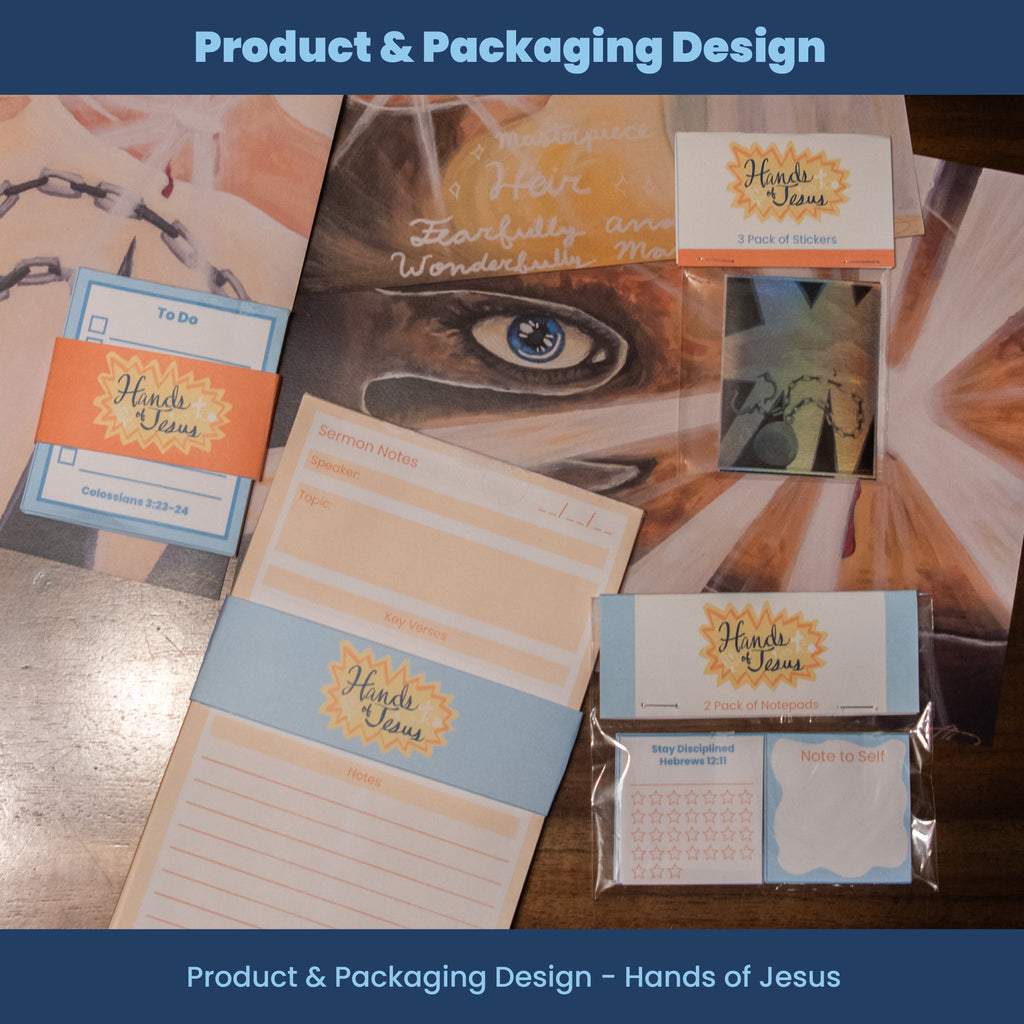 Collection of product packaging and stationery items with 'Hands of Jesus' branding on a wooden surface.